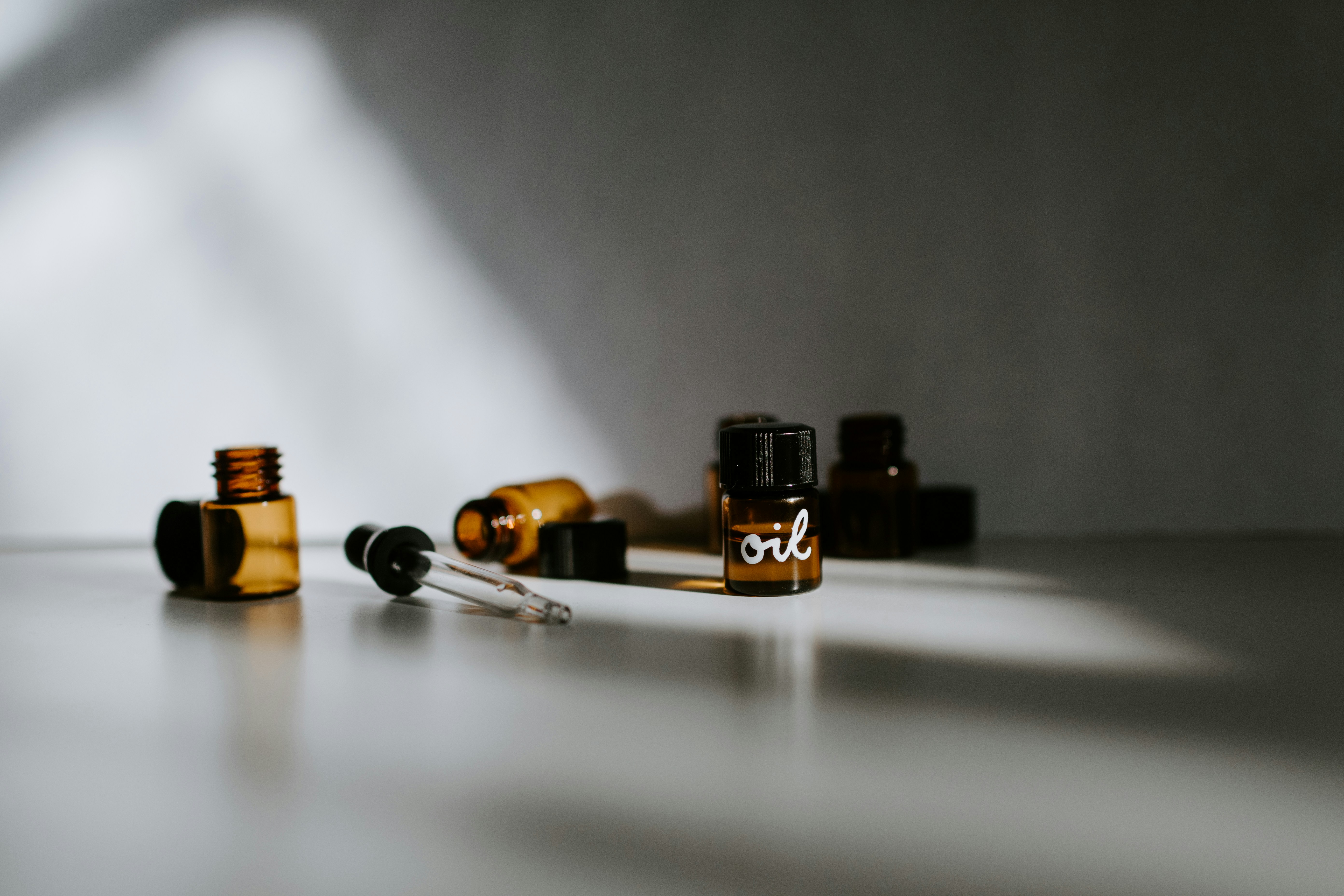 Amber glass oil bottles and a dropper in natural light